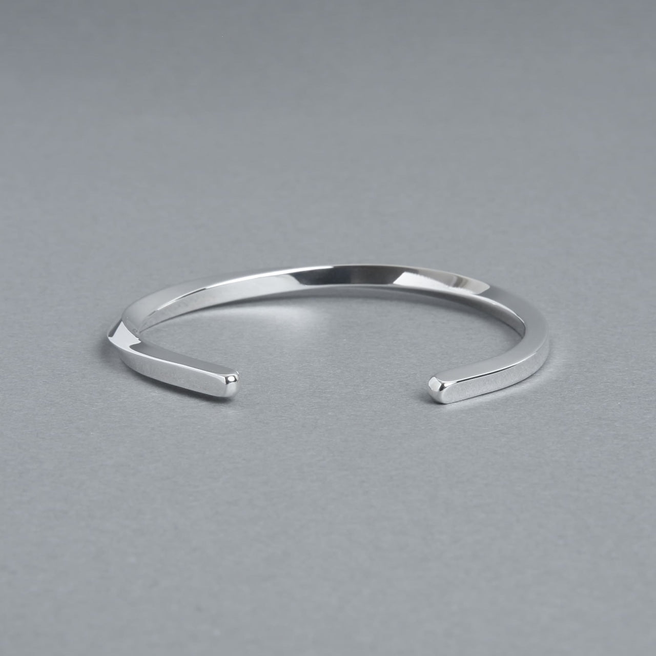 シルバー925製のシンプルなバングル。細身のオープンデザインで、洗練された鏡面仕上げが特徴。