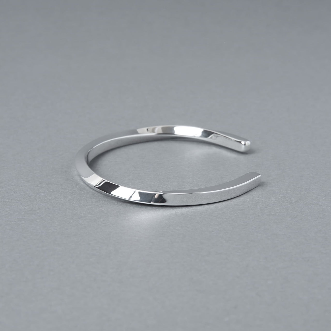 シルバー925製のシンプルなバングル。細身のオープンデザインで、洗練された鏡面仕上げが特徴。