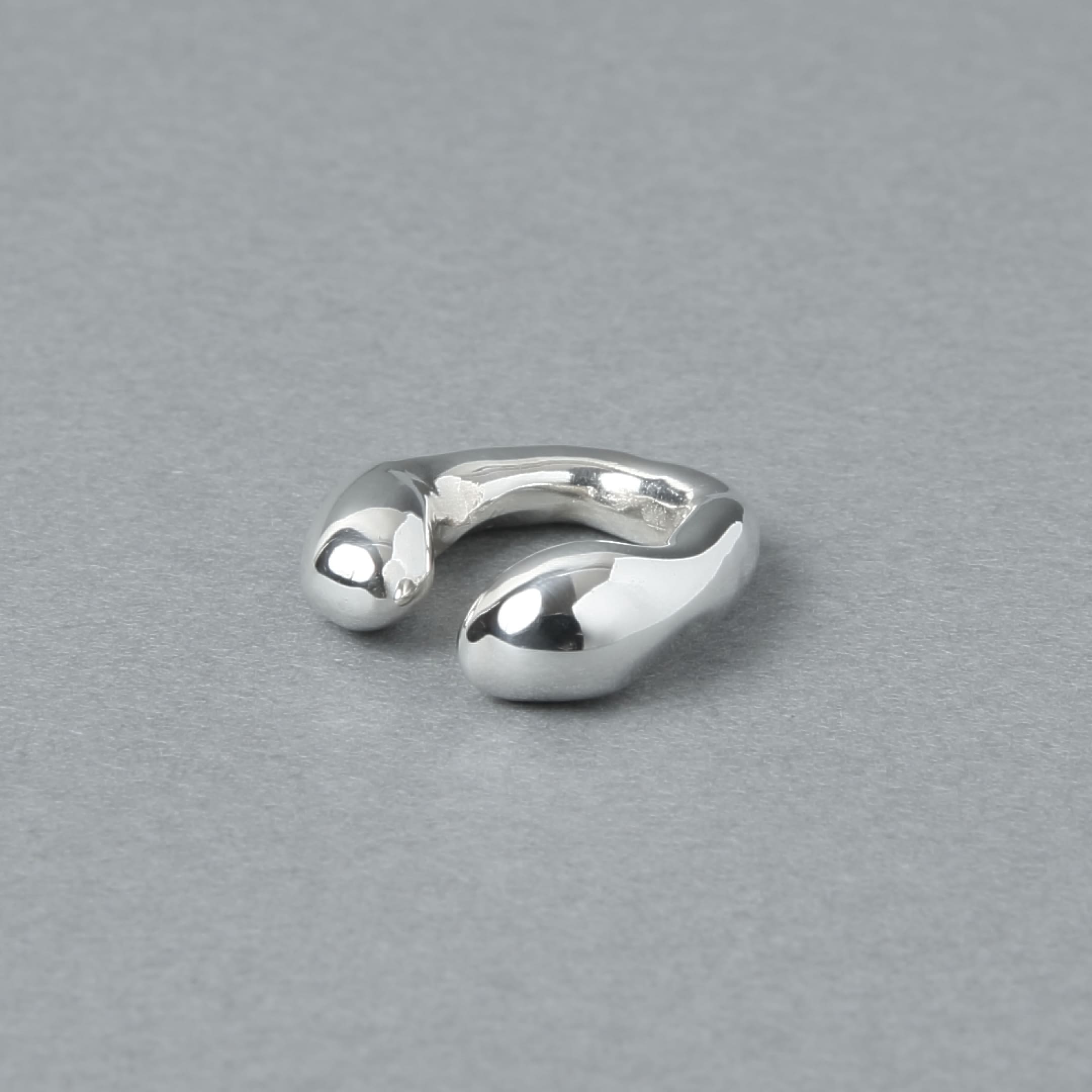 シルバー925を使用した、有機的なラインが美しいイヤーカフ。光沢のあるシルバーの質感が際立つ、シンプルながら存在感のあるデザイン。