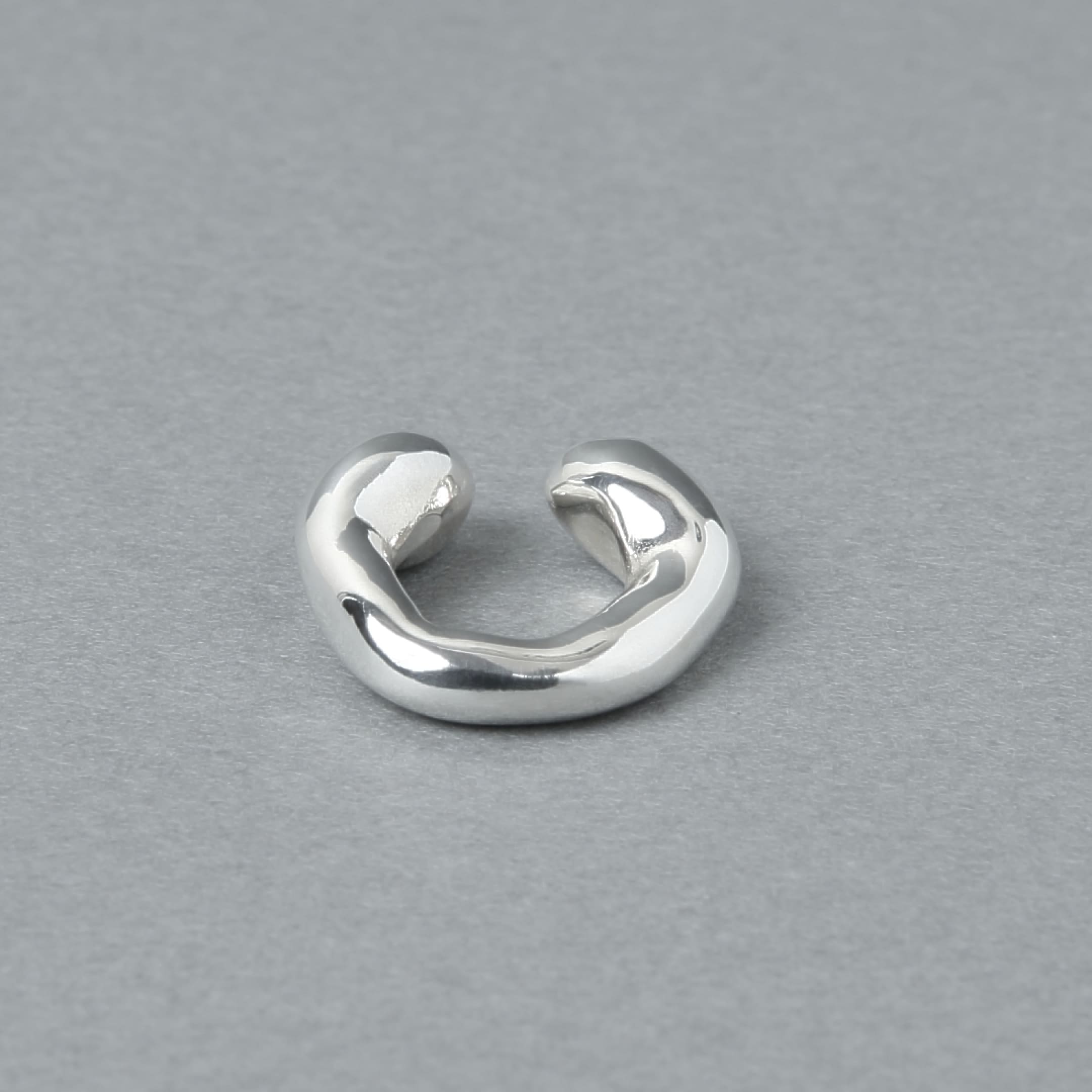 シルバー925を使用した、有機的なラインが美しいイヤーカフ。光沢のあるシルバーの質感が際立つ、シンプルながら存在感のあるデザイン。