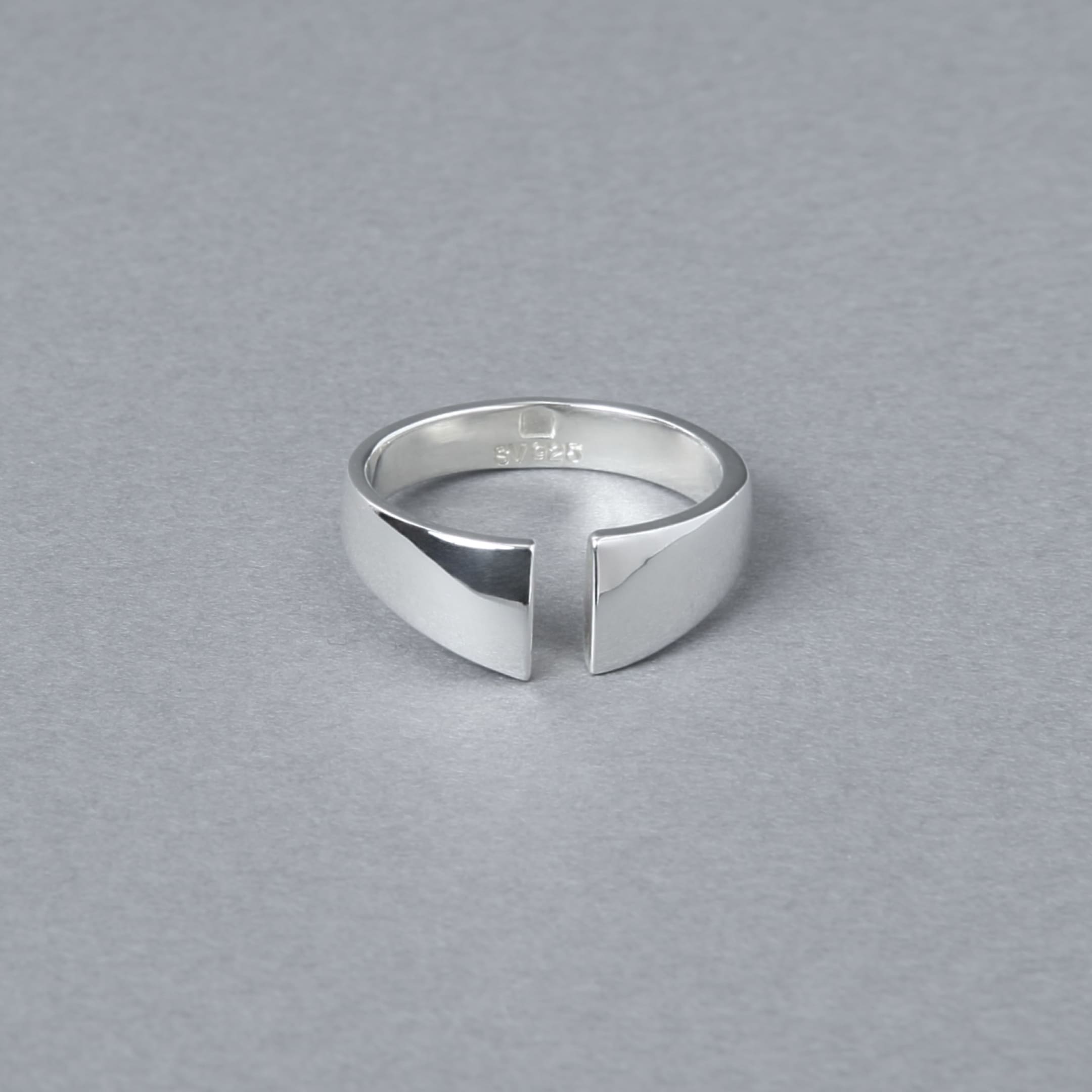 シルバー925製のオープンデザインリング。シンプルでモダンなカットラインが特徴で、光沢のある鏡面仕上げが施されている。