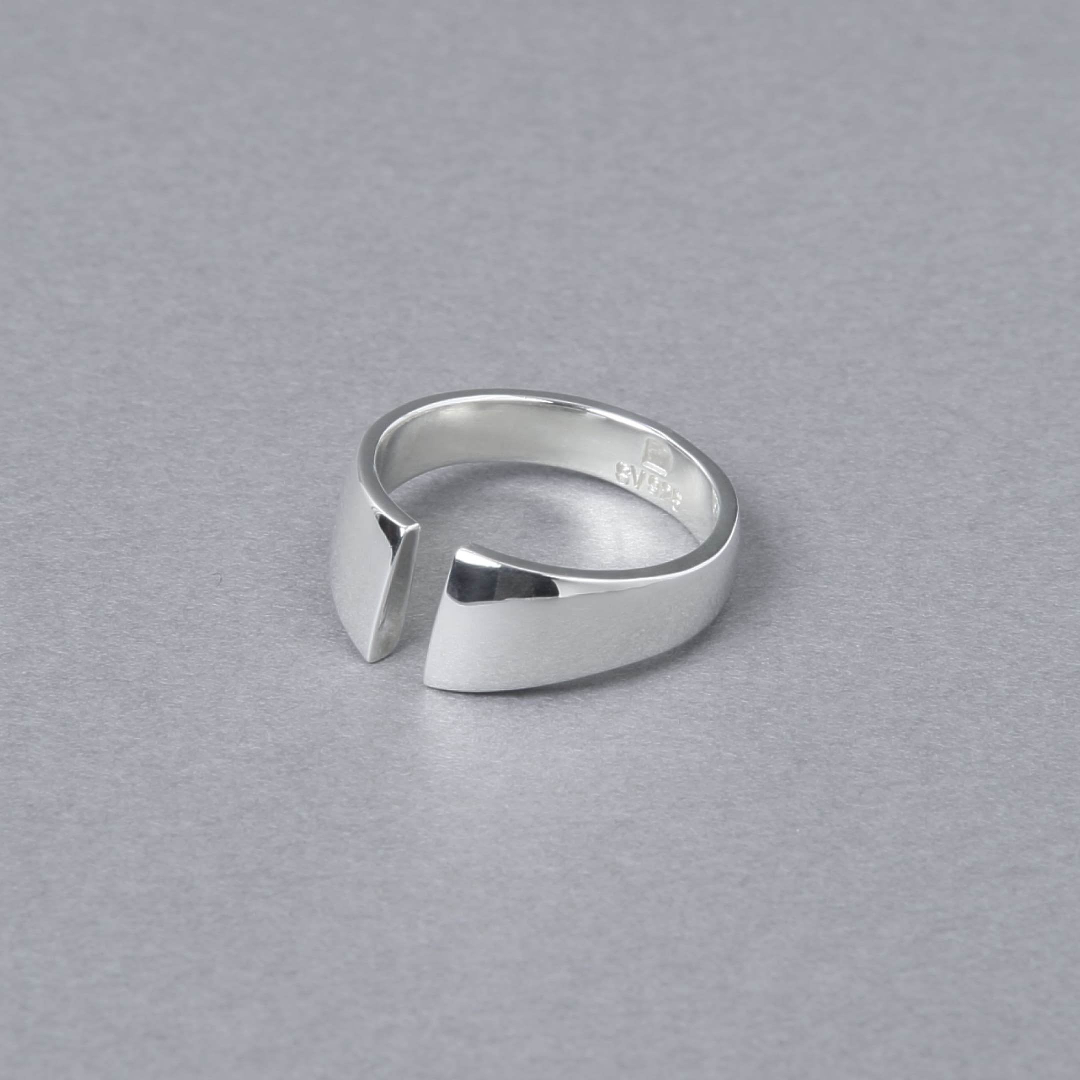 シルバー925製のオープンデザインリング。シンプルでモダンなカットラインが特徴で、光沢のある鏡面仕上げが施されている。