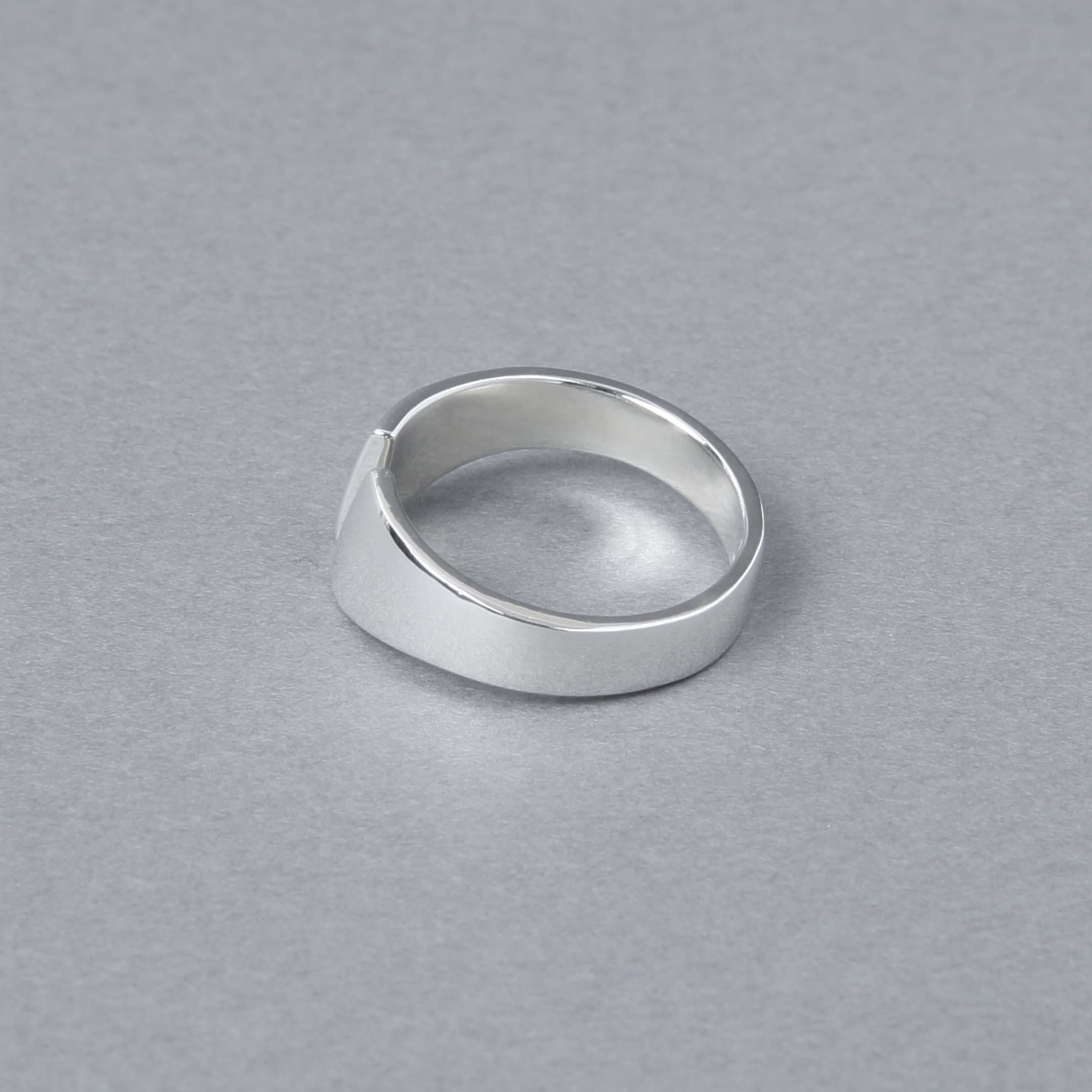 シルバー925製のオープンデザインリング。シンプルでモダンなカットラインが特徴で、光沢のある鏡面仕上げが施されている。