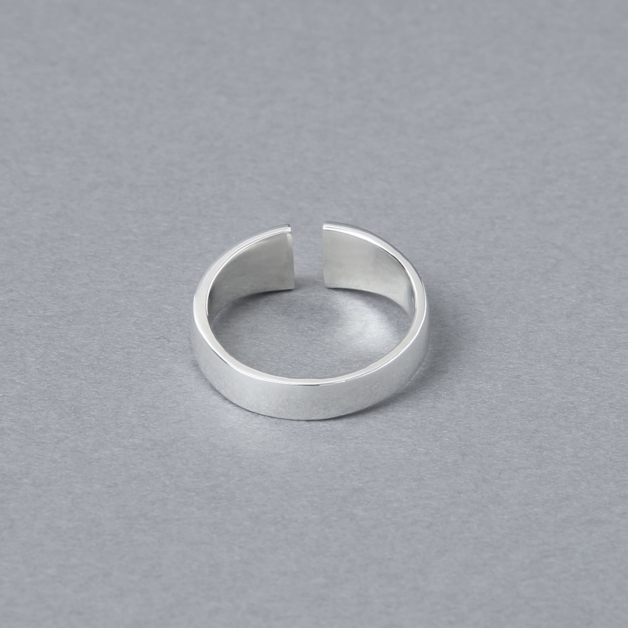 シルバー925製のオープンデザインリング。シンプルでモダンなカットラインが特徴で、光沢のある鏡面仕上げが施されている。