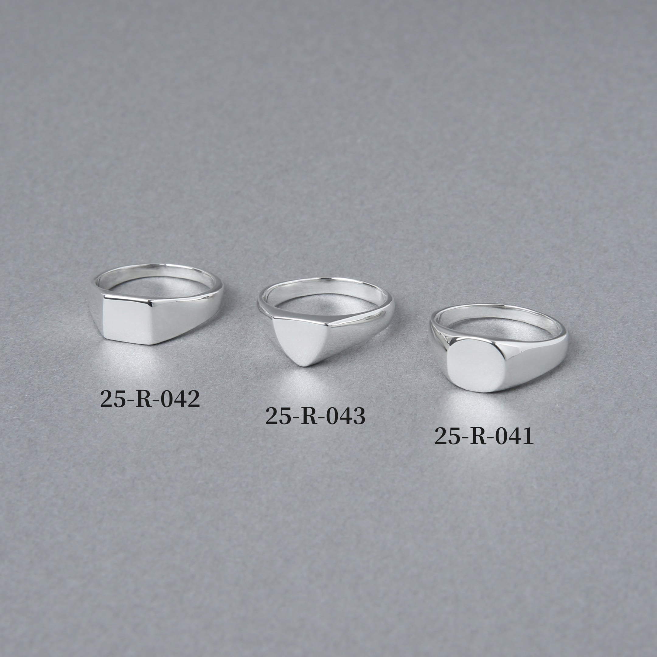 スクエア、トライアングル、ラウンドの3種類のシグネットリングを並べた比較画像。左端に「25-R-042」としてラウンド型リングが配置されている。