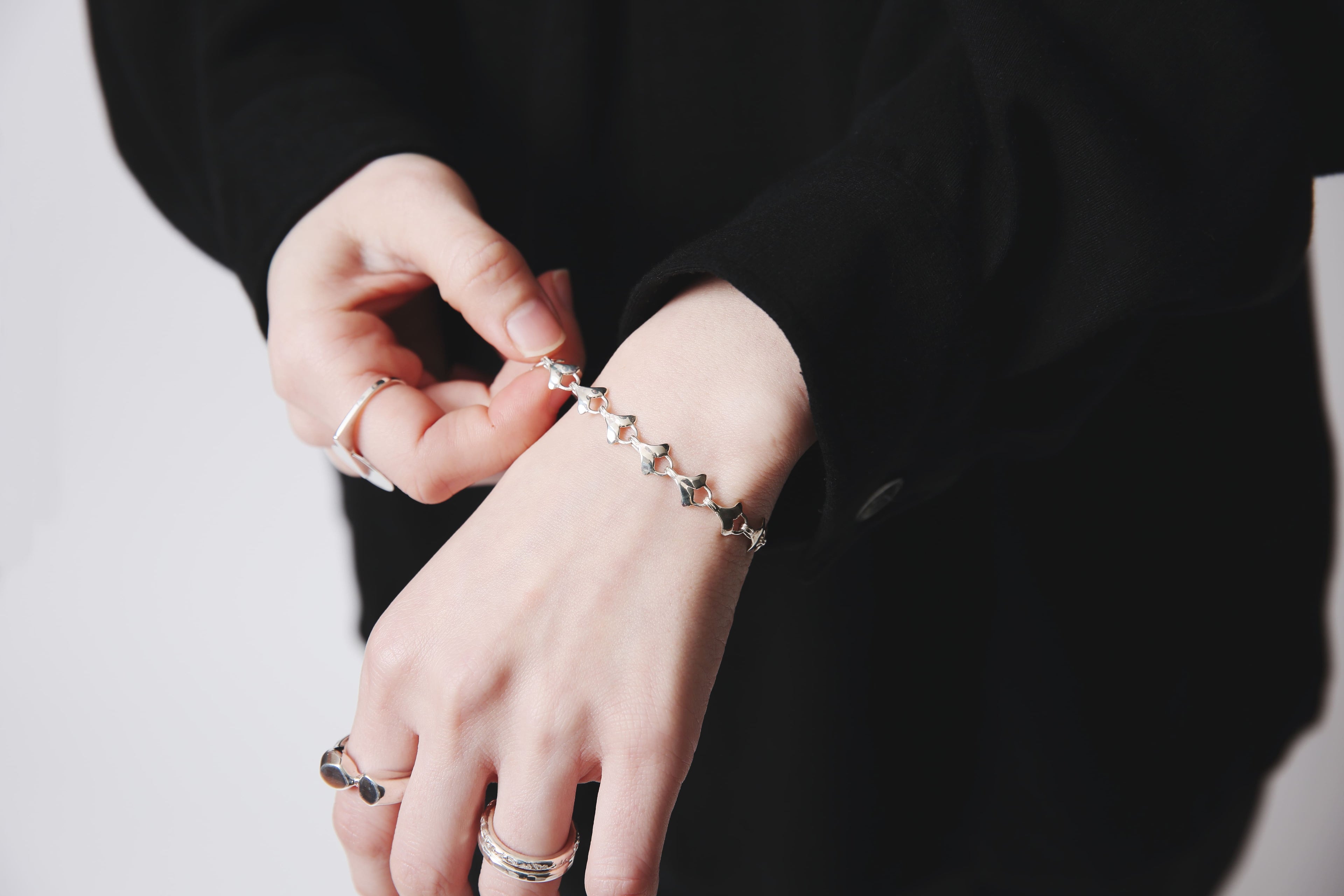 手元をクローズアップしたカットで、ブレスレットの一枚一枚の葉が立体的に見える。柔らかな陰影がシルバーの艶を引き立てる。