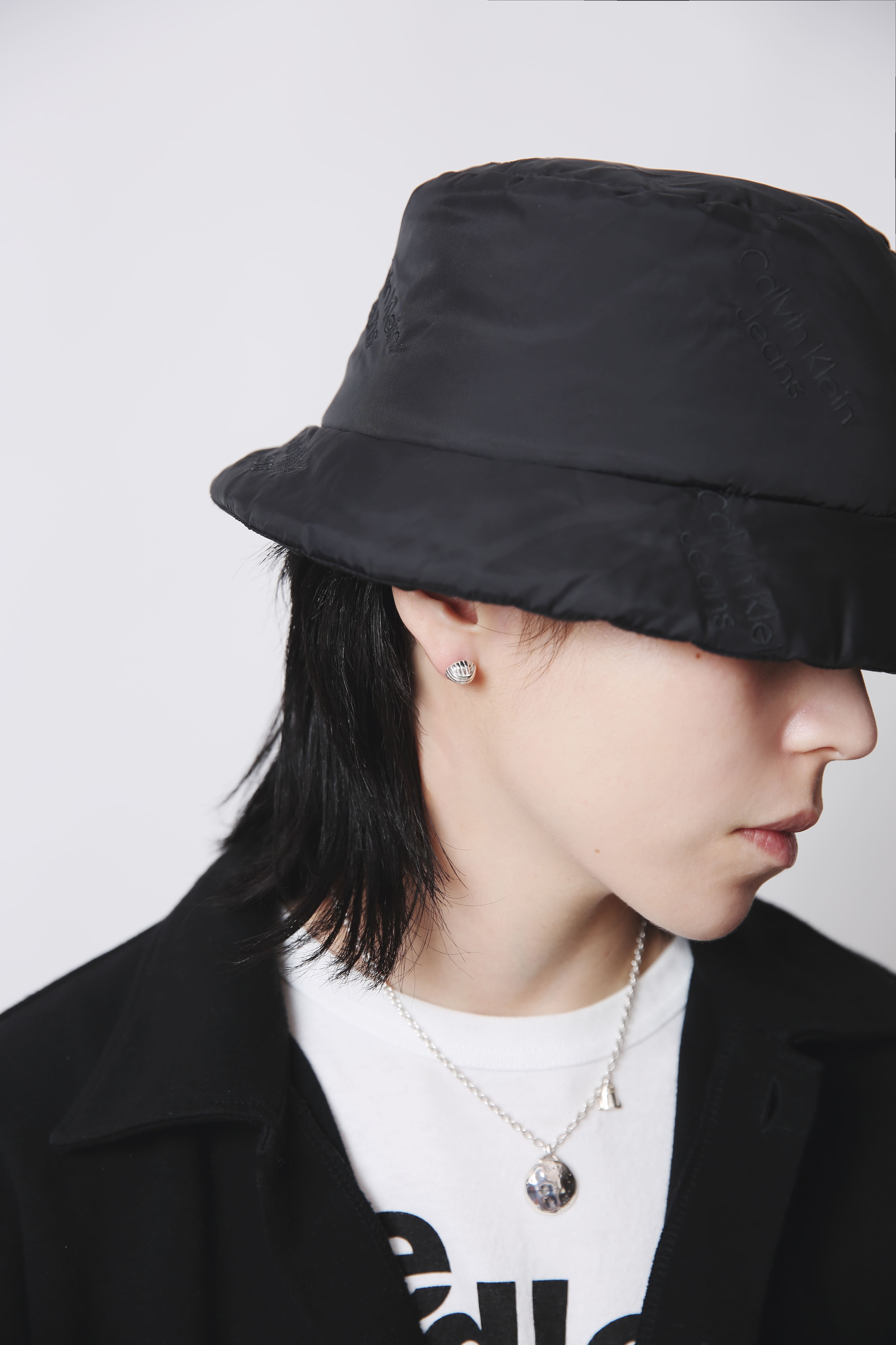 黒のバケットハットとジャケットを合わせたストリートスタイルに、シルバー925のピアスがさりげない光のアクセントを添える着用カット。