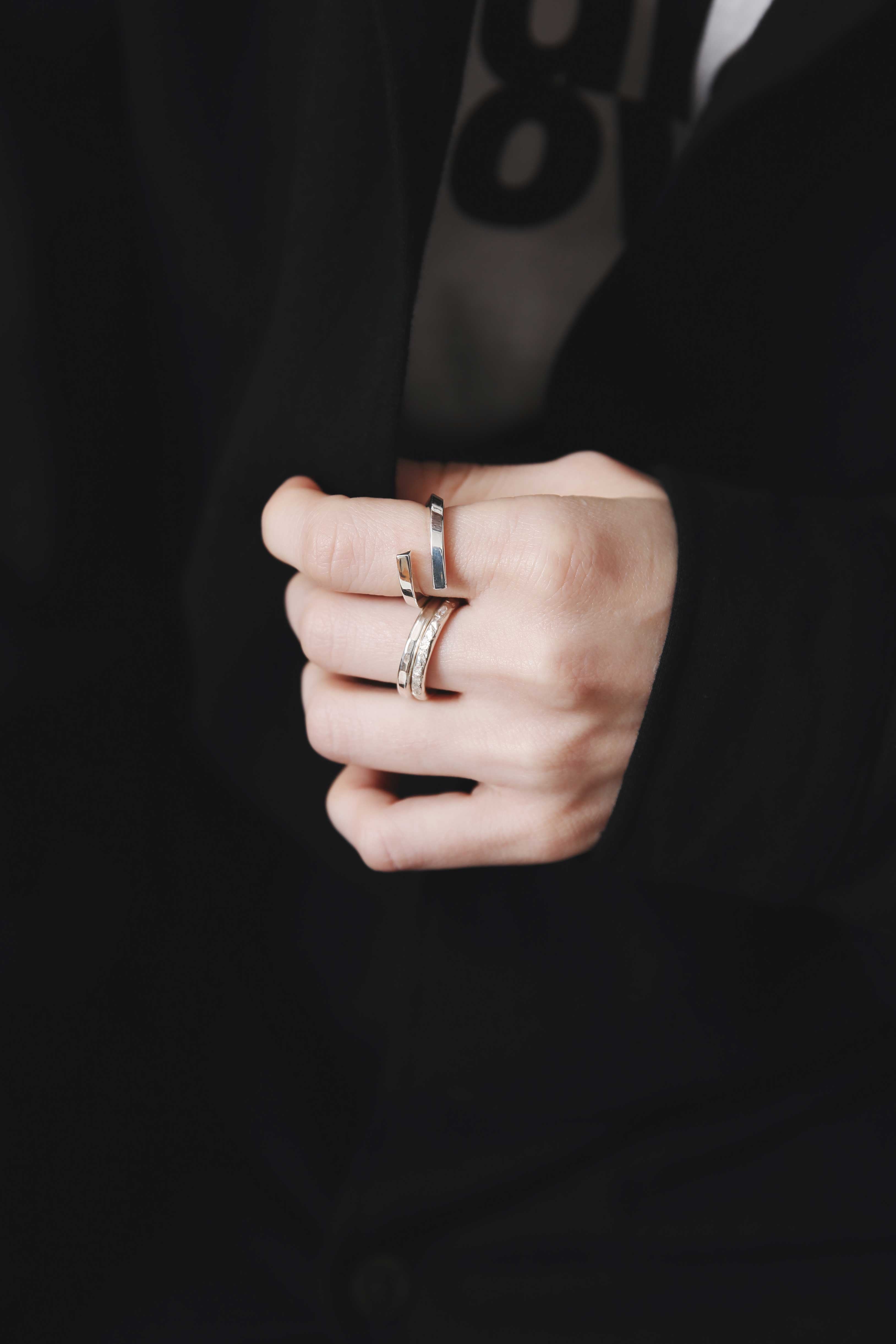 Nine Nineの艶やかなシルバー925オープンリングと槌目模様リングを重ねた指先