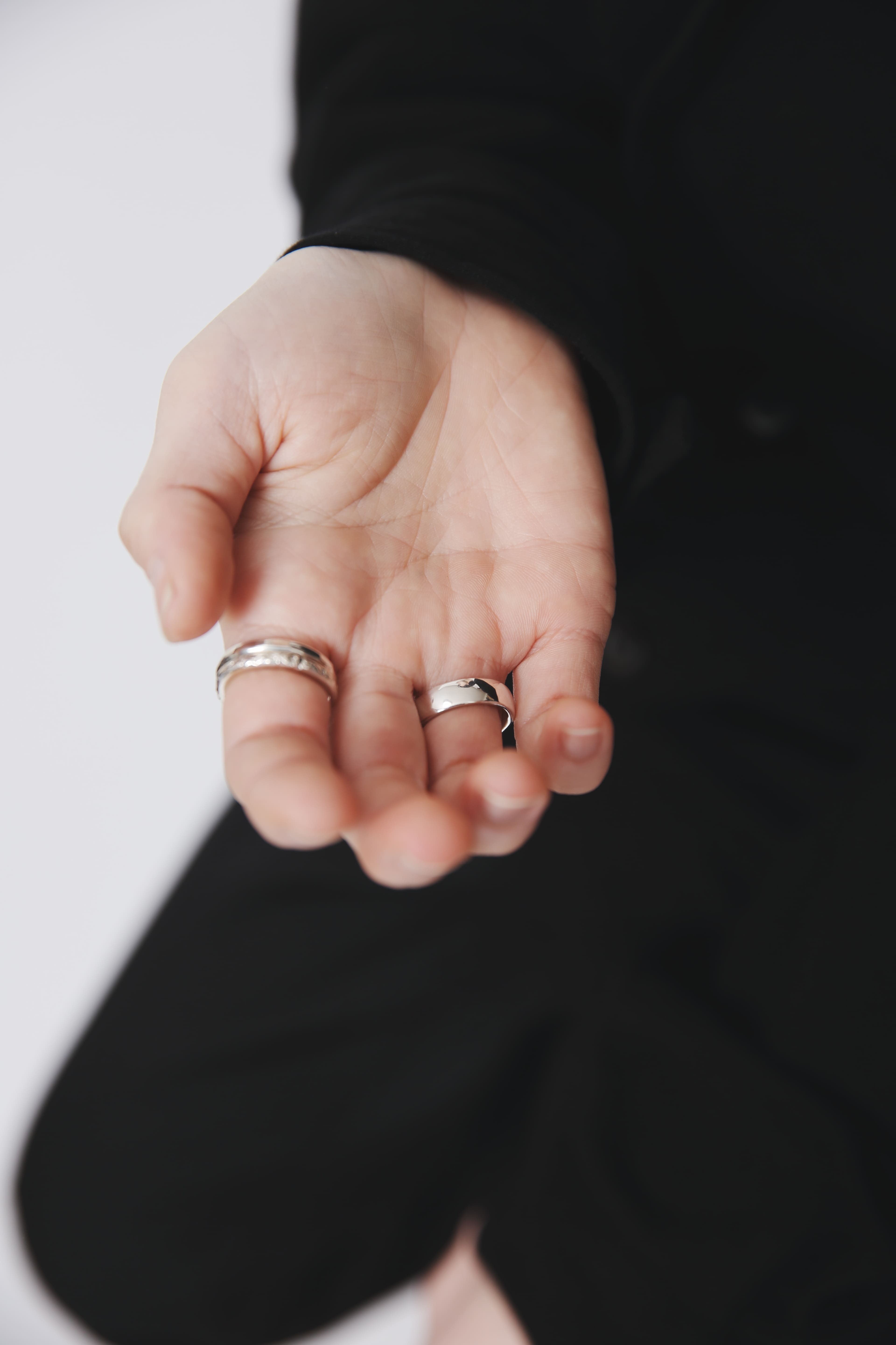 手のひらに置いたシルバー925リング2種(プレーン&テクスチャー)。重ね付けやサイズ感が分かるディテール。