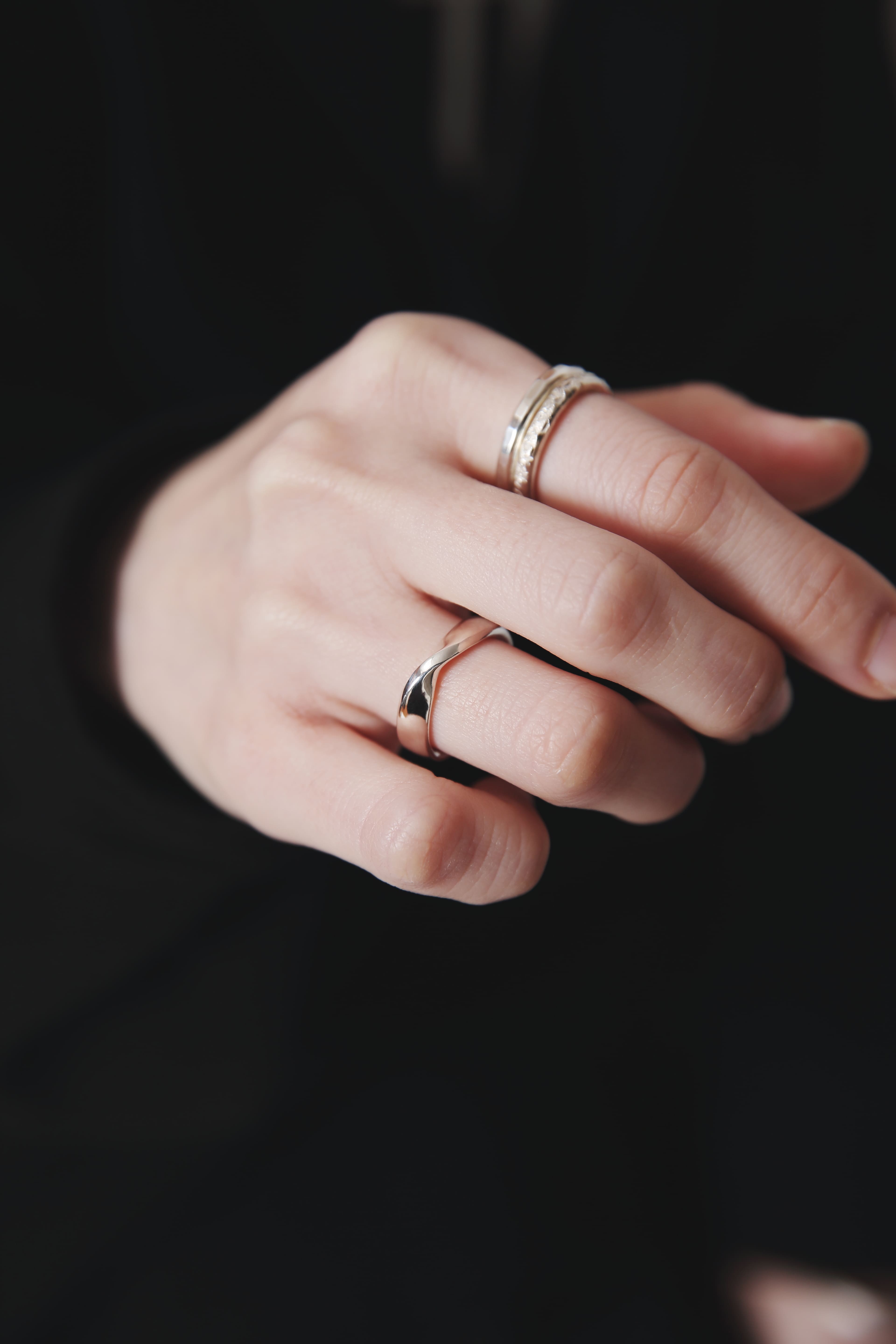 重ね付けリングのクローズアップ。鏡面と槌目テクスチャーのコントラストが際立つシルバー925。