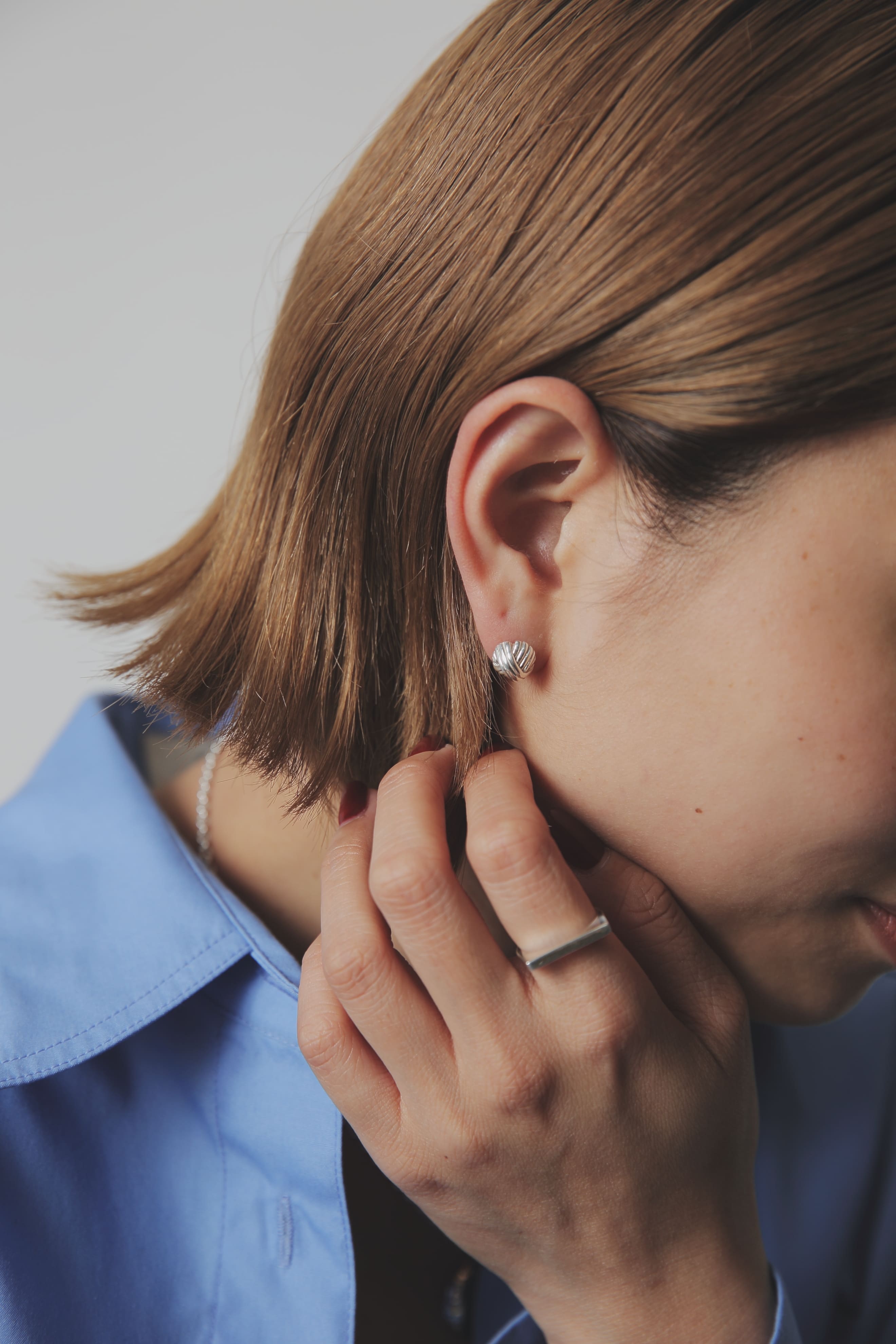 ブルーのシャツに合わせた、クリーンで洗練された印象の着用イメージ。シルバー925ならではの明るい輝きが顔周りを華やかにします。