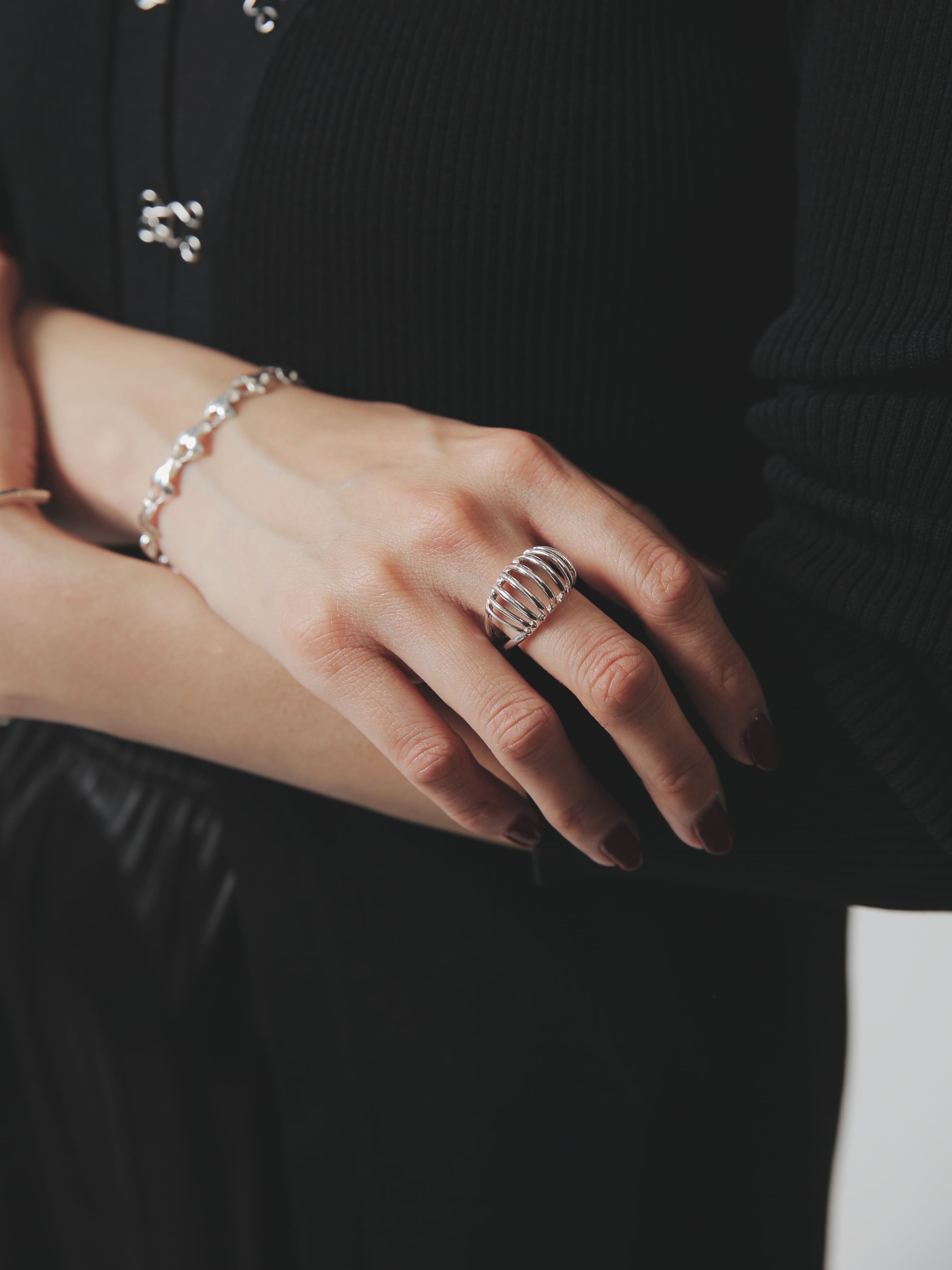 立体的な曲線が特徴的なシルバー925リングを斜め前から撮影。抜け感のある構造が指元を美しく演出。