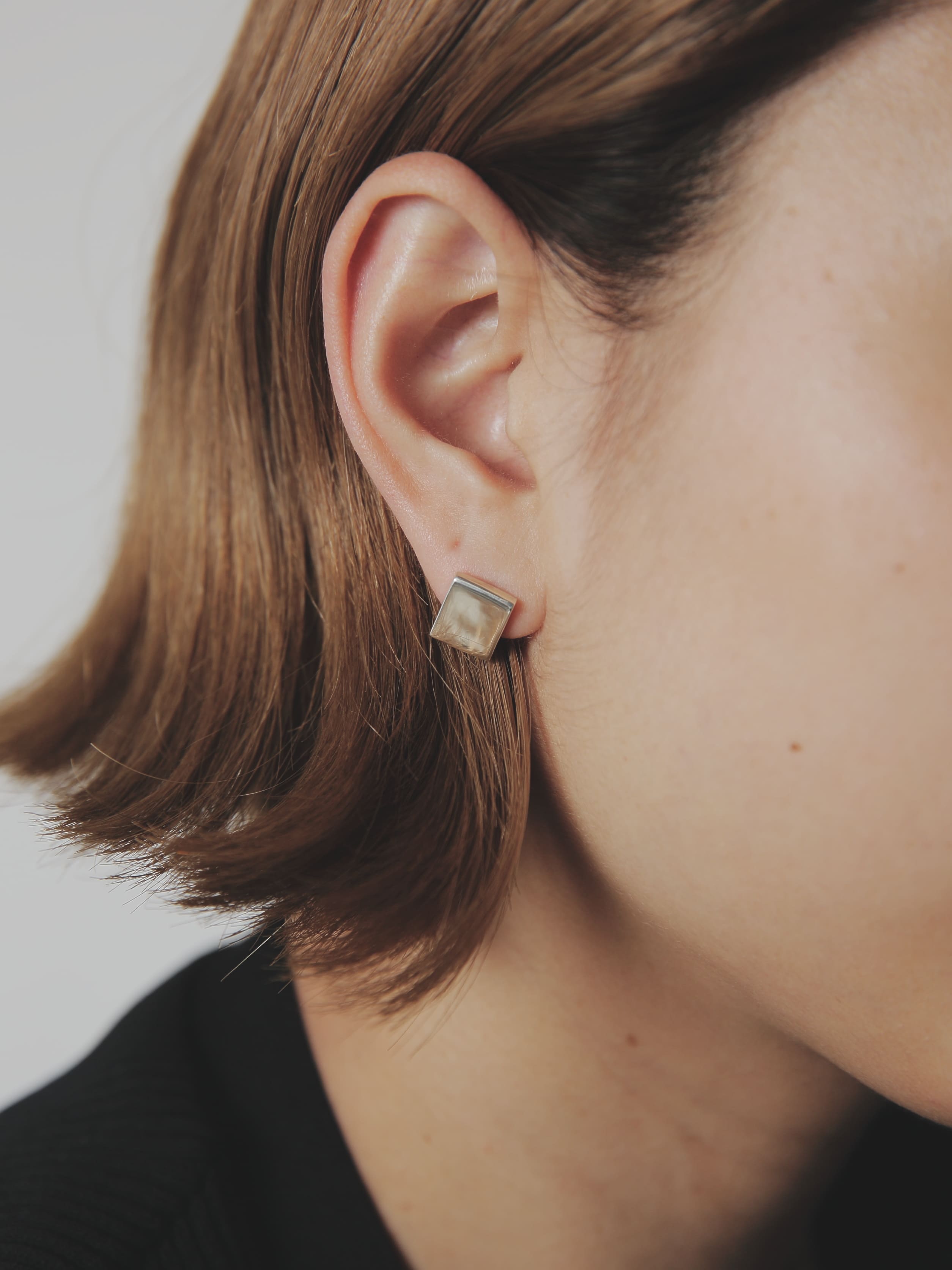 ミニマルなデザインのシルバー925スクエアピアス。無駄を削ぎ落とした正方形のシルエットが、日常のコーディネートに上品なアクセントを添えるシルバー925アクセサリーのディテール。