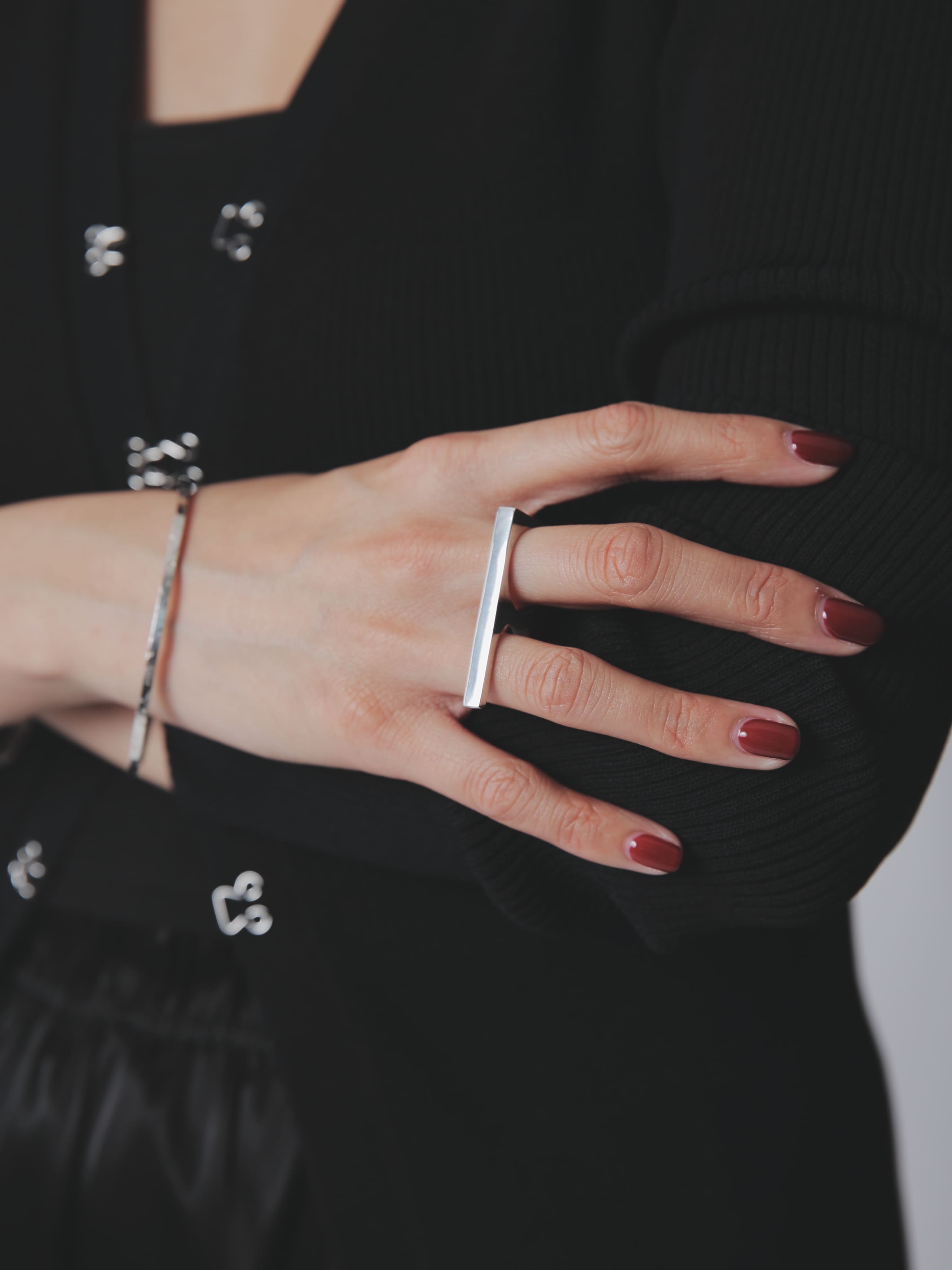 直線的なデザインが印象的なシルバー925リングを主役にした手元のスタイリング。シンプルな黒コーデとの洗練されたコントラスト