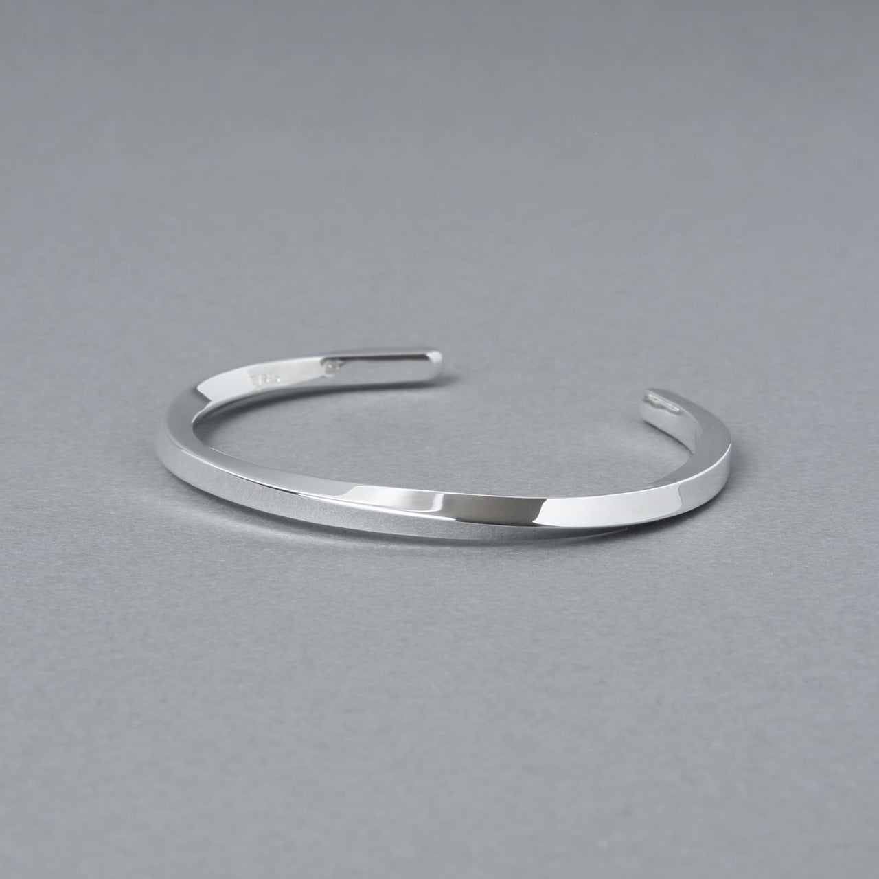 シルバー925製のシンプルなバングル。細身のオープンデザインで、洗練された鏡面仕上げが特徴。