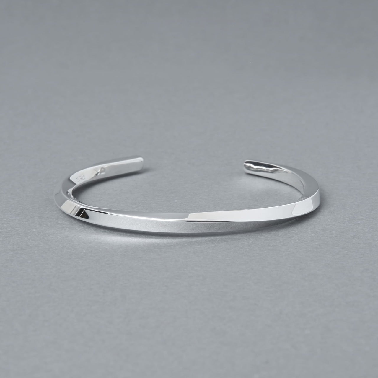 シルバー925製のシンプルなバングル。細身のオープンデザインで、洗練された鏡面仕上げが特徴。