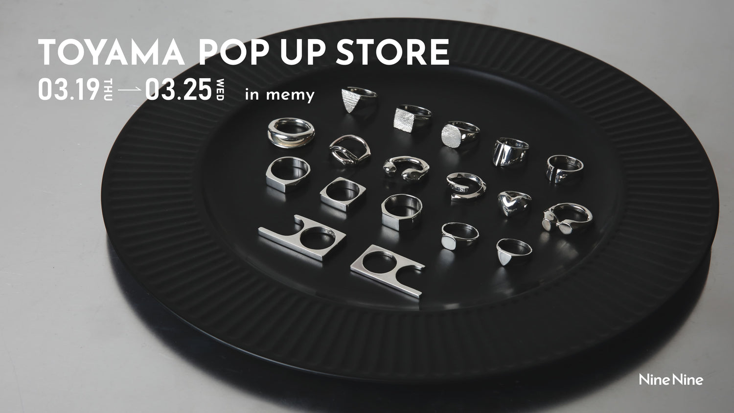 ブラックの大皿に並べられたシルバーリングのコレクションを写したビジュアル。「TOYAMA POP UP STORE 03.19 THU — 03.25 WED in memy」のテキスト入り告知画像。Nine Nineのポップアップストア案内。