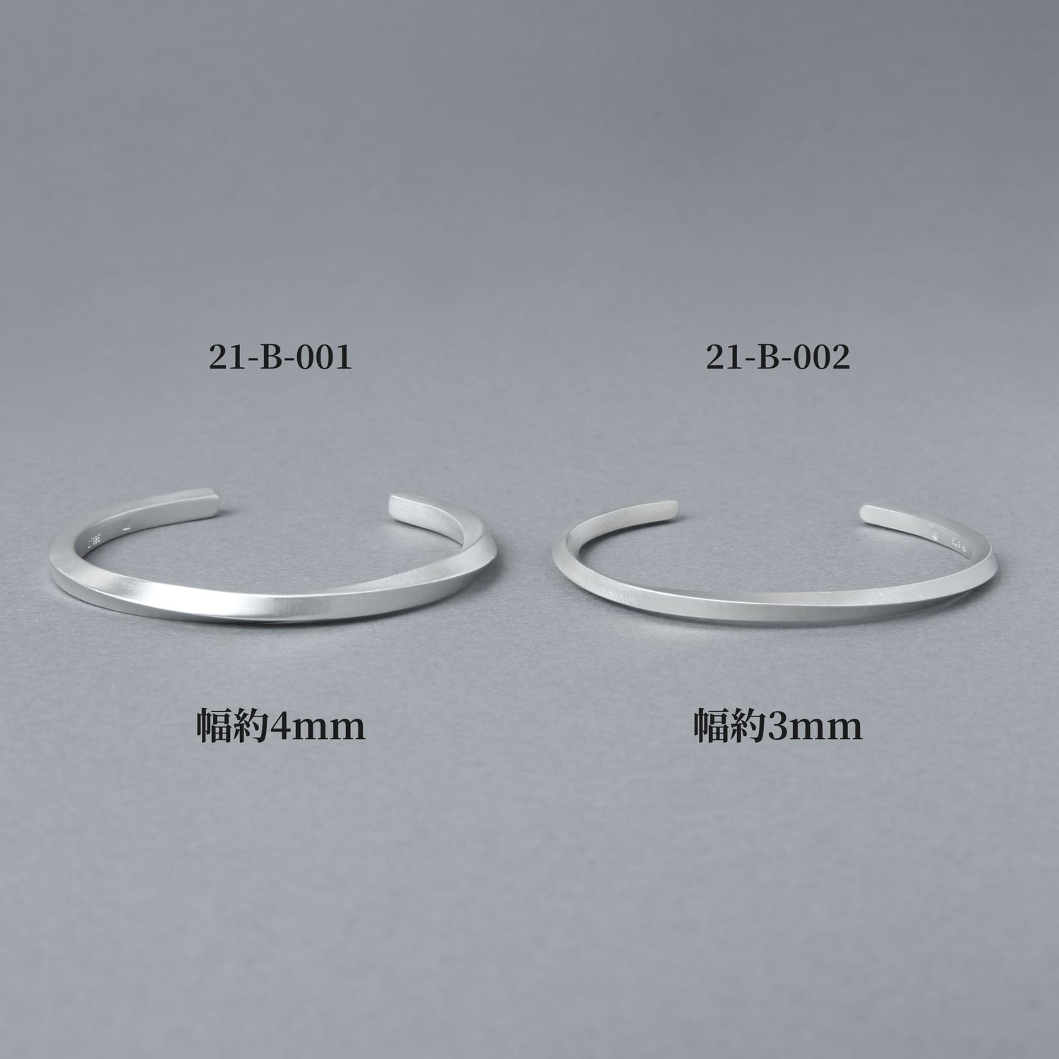 品番21-B-001（幅約4mm）と21-B-002（幅約3mm）のシルバーバングルを並べた比較画像。マット仕上げの質感と幅の違いが分かる商品イメージ。