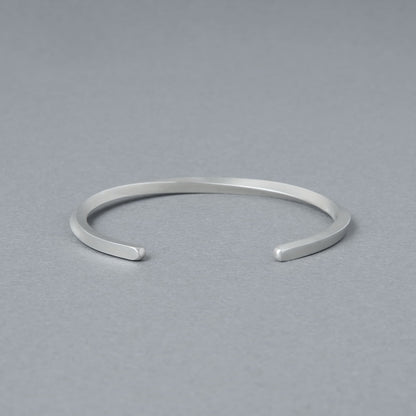開口部が正面に見える構図のシルバーバングル。シンプルな丸みと均整の取れたフォルムを強調した商品イメージ。