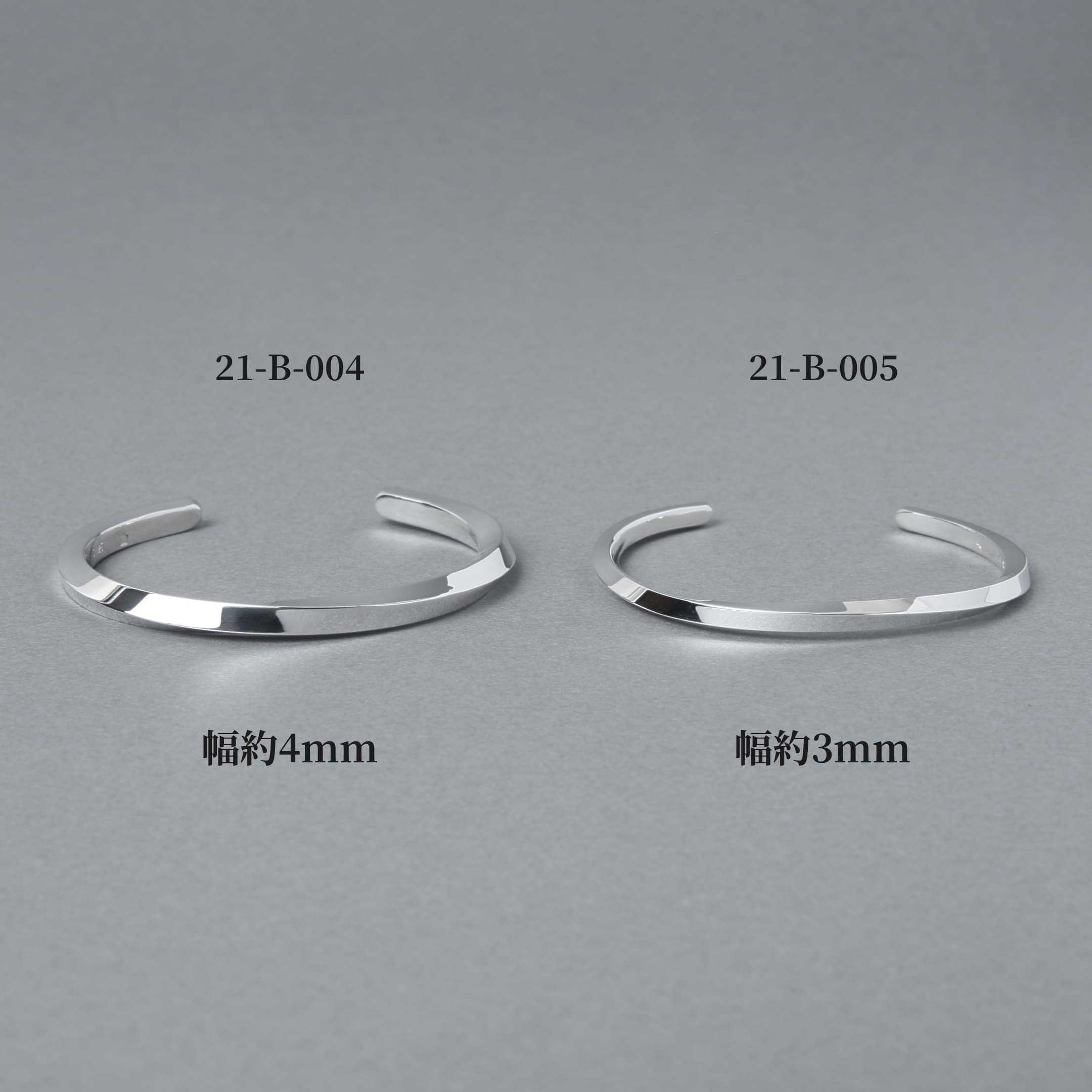 品番21-B-004（幅約4mm）と21-B-005（幅約3mm）のシルバーバングルを並べた比較画像。プレーンでフラットなフォルムの幅違いデザインをグレー背景で撮影した商品イメージ。