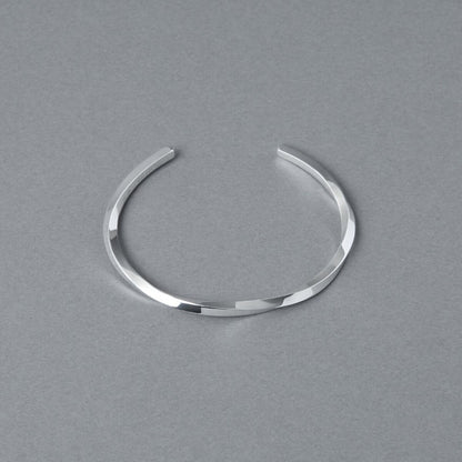 シルバー925バングル「21-B-005」（幅3mm）を、開口部を上に向けてグレー背景で上方から撮影。ねじりのあるフォルムと鏡面仕上げの輝き、全体の形状が見える商品写真。