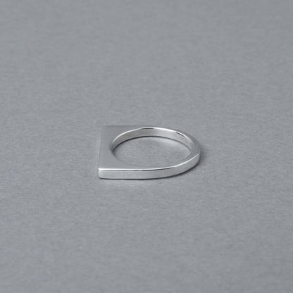 斜め横から見た、ミニマルなデザインのシルバー925製リング。指の背にあたる部分がフラットに切り落とされたような、スタイリッシュな形状が特徴です。