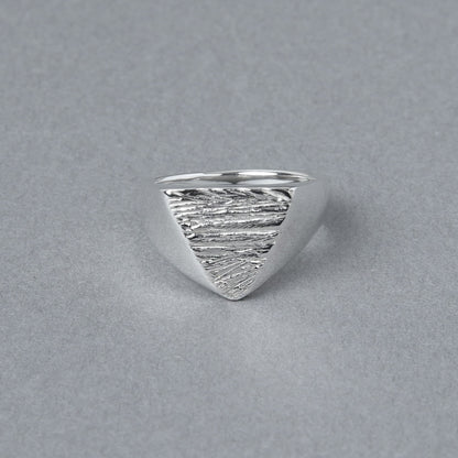 三角形のトップに木目のようなテクスチャが施されたシルバー925シグネットリング。正面から見た写真で、エッジの効いたフォルムが印象的。