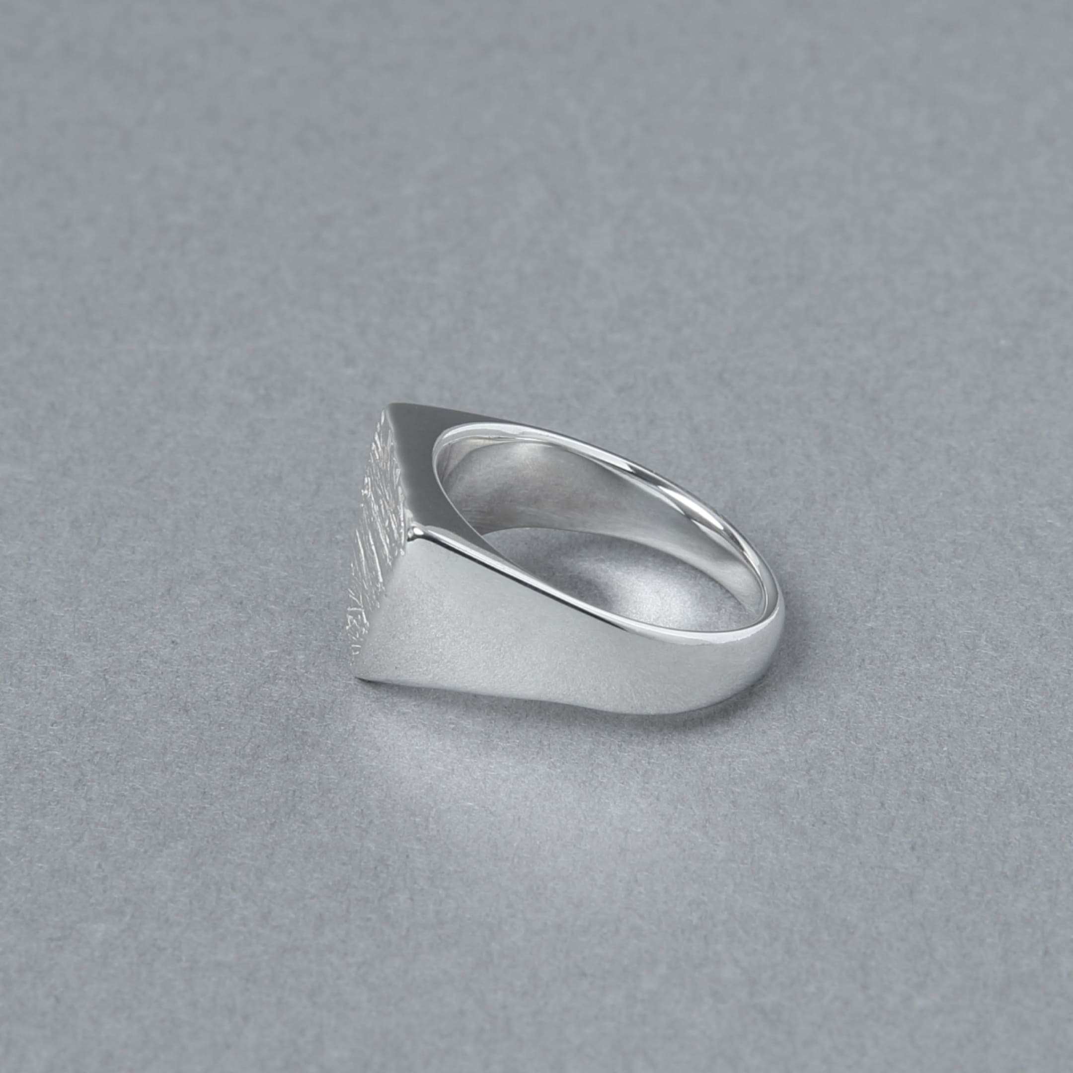 リングを横から撮影した画像。トップからアームにかけての厚みの変化が美しく、磨き上げられた鏡面が高級感を演出している。