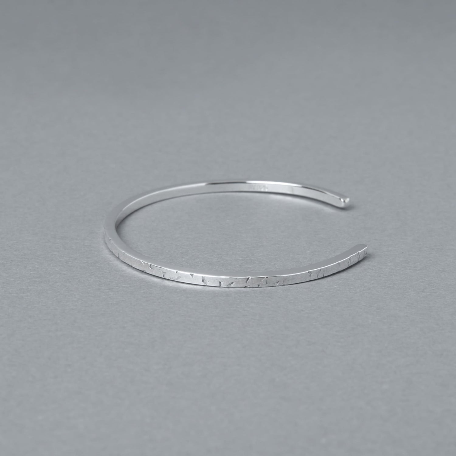 シルバー925の細身バングルを斜め上から撮影したミニマルデザインのブレスレット