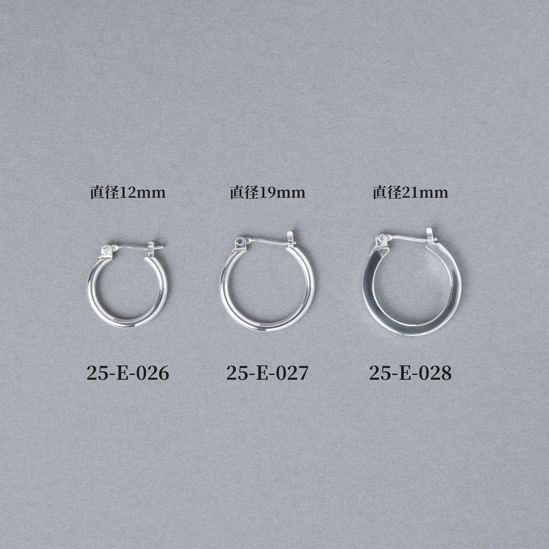 グレー背景に並べられた3サイズのフープピアス。左から直径12mmの25-E-026、19mmの25-E-027、21mmの25-E-028と商品番号とサイズが表示されている比較画像。