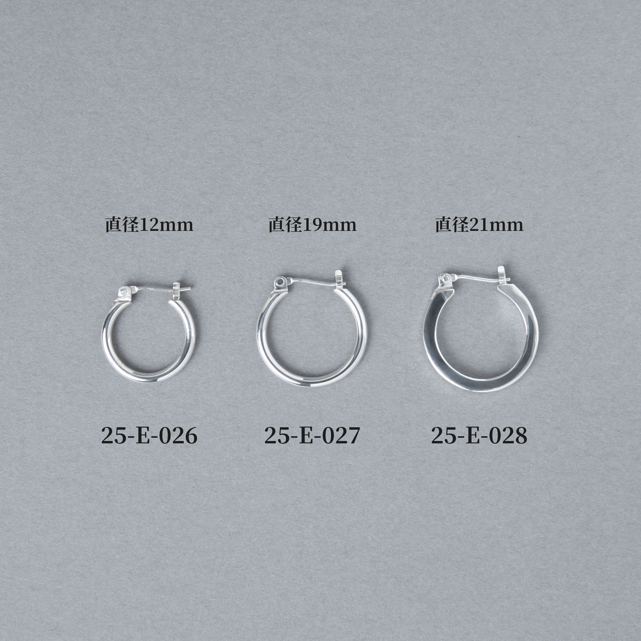 グレー背景に並べられた3サイズのフープピアス。左から直径12mmの25-E-026、19mmの25-E-027、21mmの25-E-028と商品番号とサイズが表示されている比較画像。