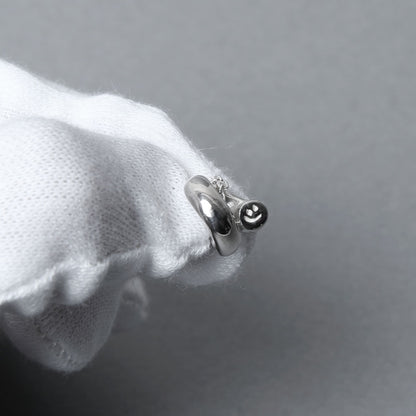 白手袋の上で撮影されたシルバー925のペンダントネックレス。丸みのあるモチーフが艶やかに光を映し出す繊細な造形。