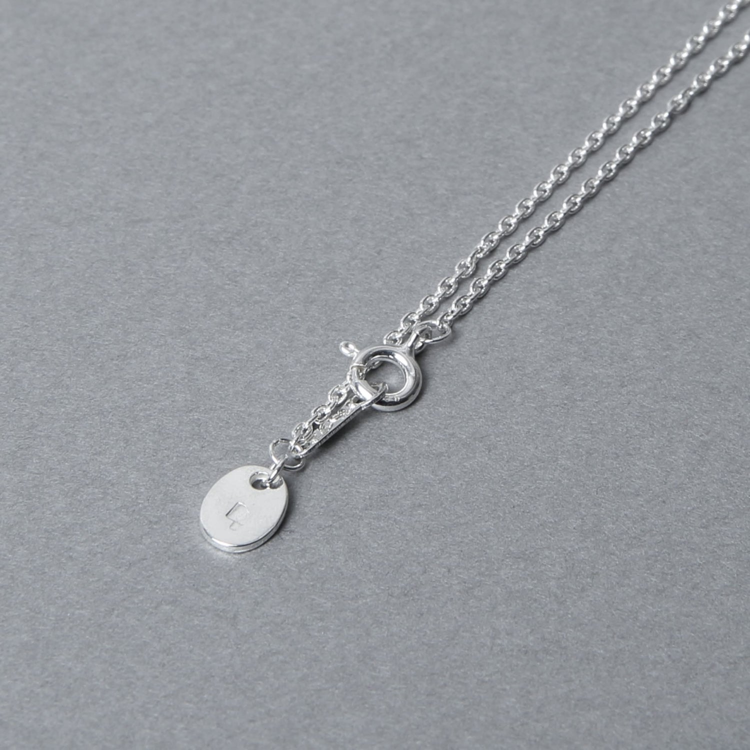 シルバー925チェーンの留め具部分。Nine Nineの刻印入りチャームが付属し、細部まで丁寧に仕上げられたデザイン。