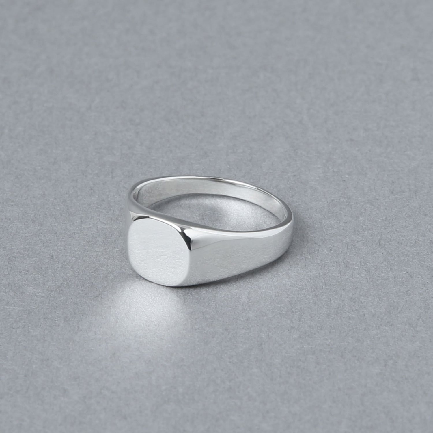 やや斜め前から見たラウンド型のシグネットリング。滑らかに磨き上げられたラウンドトップが光を柔らかく反射している。