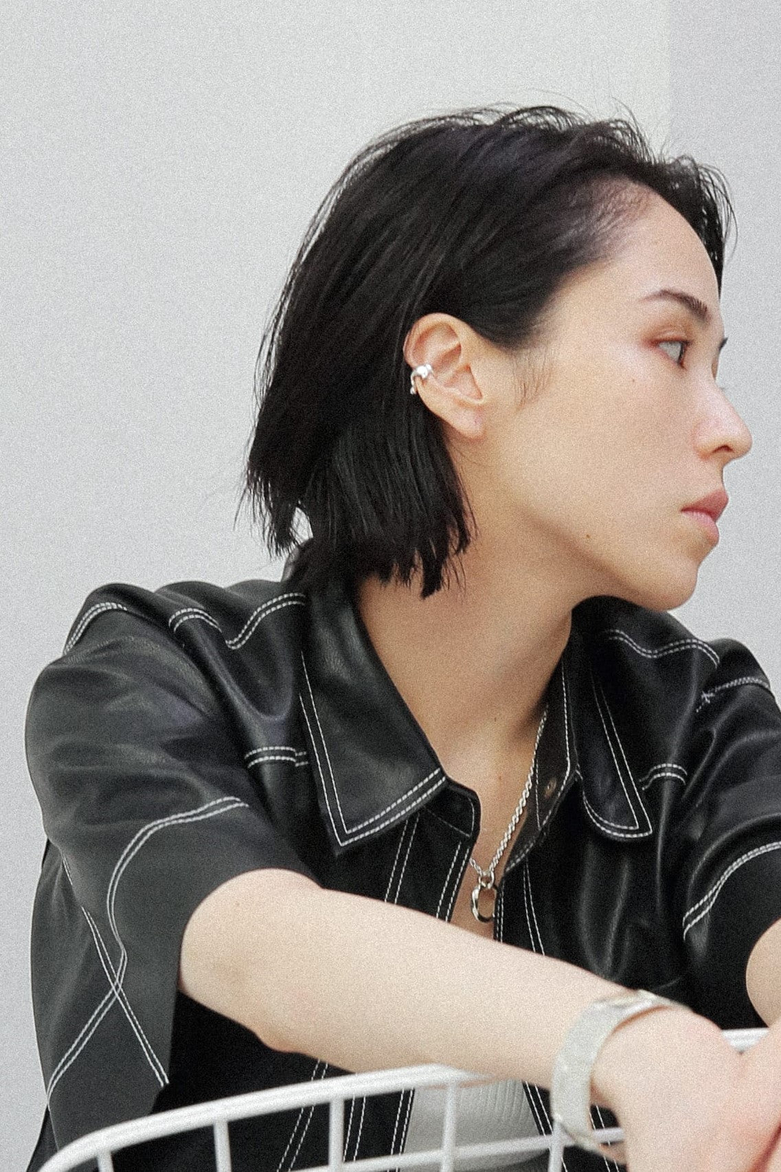 耳元にシルバー925のイヤーカフを着用したスタイル。滴るような有機的なフォルムが、ブラックのレザージャケットと相まって、モードで洗練された印象を与えます。