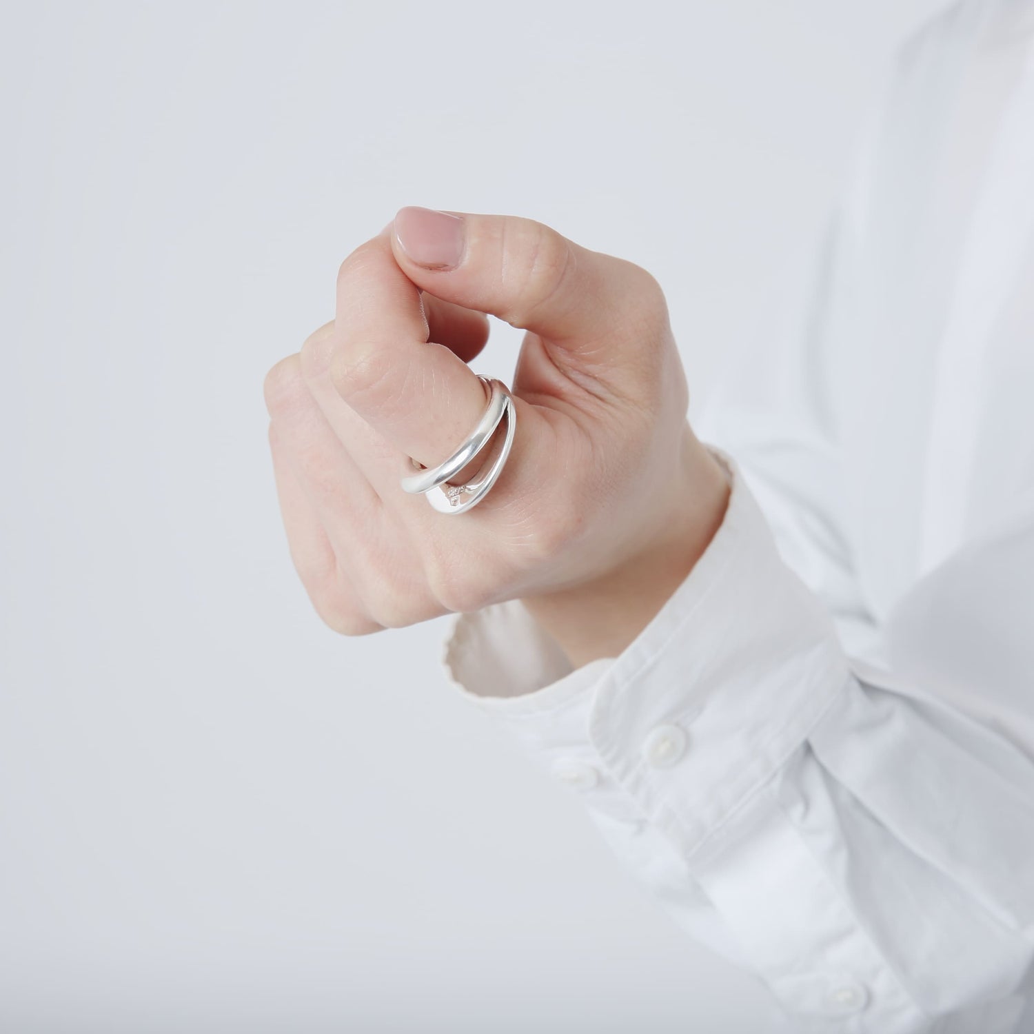 軽く拳を握ったポーズでのクローズアップ。シルバー925の質感と、内側に刻印が見えるリングのディテール。