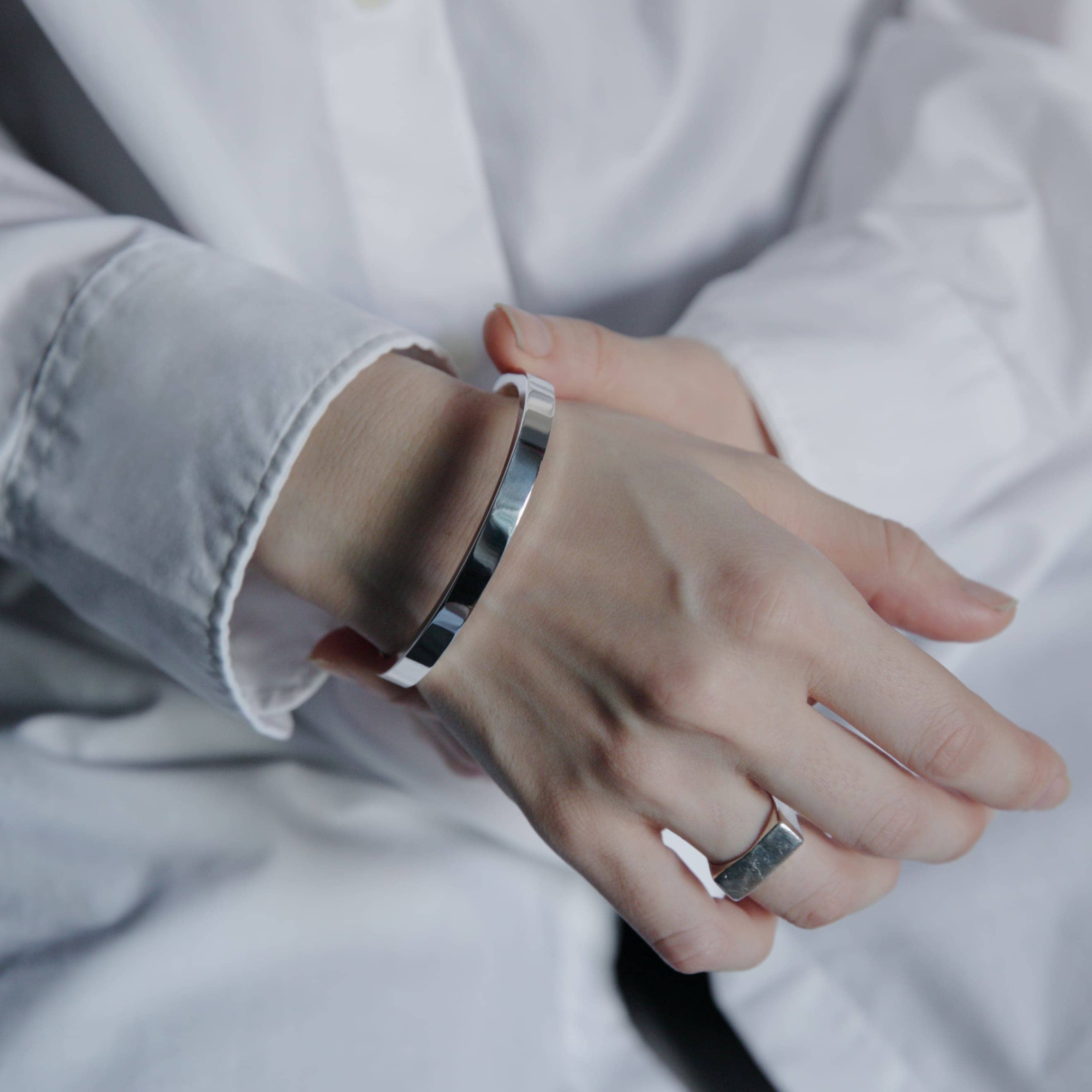 ホワイトシャツの袖口から覗くシルバー925バングル、ミニマルな手元スタイリング