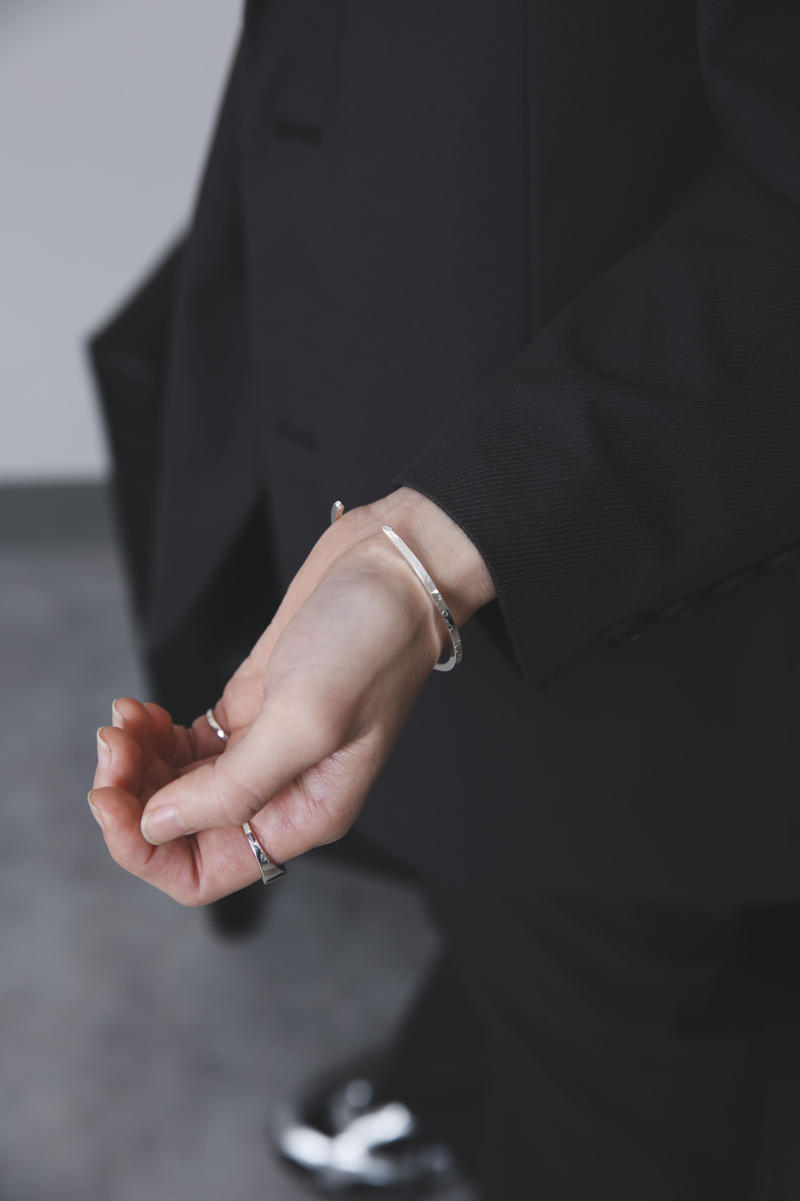 手をひらいた自然な姿勢で、反射が美しいシルバー925のバングルとリングが手元に輝く様子を捉えたカット。