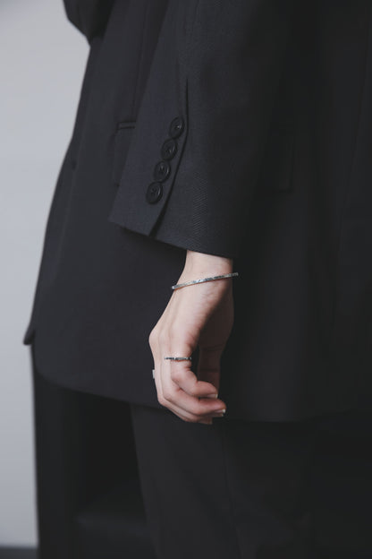 手元を引き締めるシルバー925バングルの着用クローズアップ（ブラックジャケット）