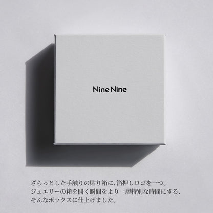 Nine Nineのロゴが中央に箔押しされた、さらりとした質感のホワイトボックス。やわらかな光と影が落ちるミニマルなパッケージイメージ。
